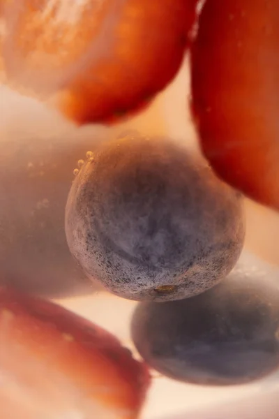 Close up view of strawberries and blueberries in glass of lemonade — Stock Photo