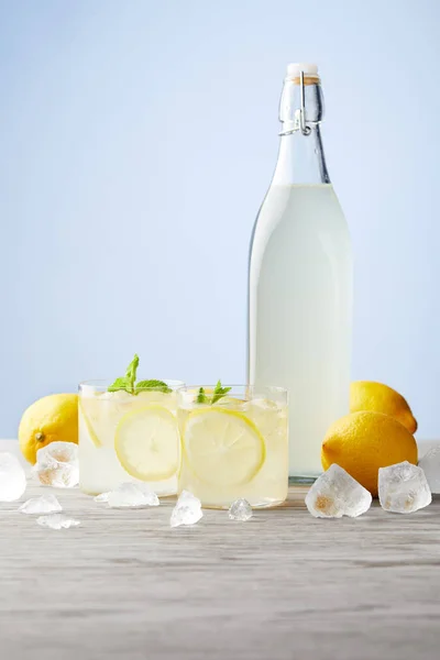 Bottiglia e bicchieri di limoncello tradizionale italiano su tavolo in legno — Foto stock