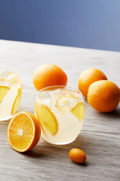 Close-up shot of glasses of orange lemonade on wooden surface — Stock Photo