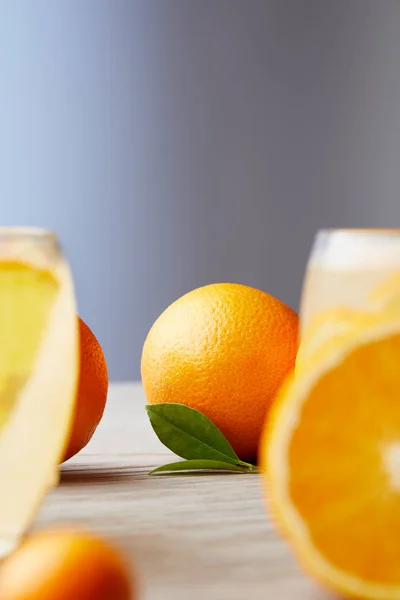 Oranges mûres et verres de cocktail sur une surface en bois — Photo de stock