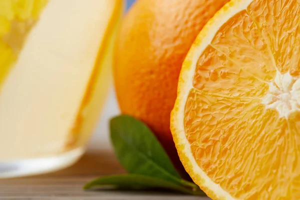 Close-up tiro de laranjas maduras com vidro de limonada na superfície de madeira — Fotografia de Stock