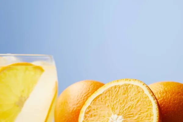 Vaso de refrescante limonada con naranjas sobre mesa de madera - foto de stock