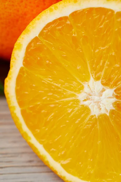 Close-up shot of half of orange on wooden surface — Stock Photo