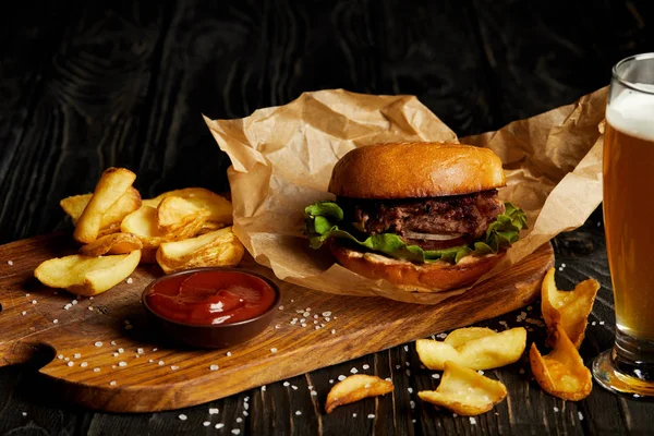 Jantar de fast food tentador com cerveja e hambúrguer na mesa — Fotografia de Stock