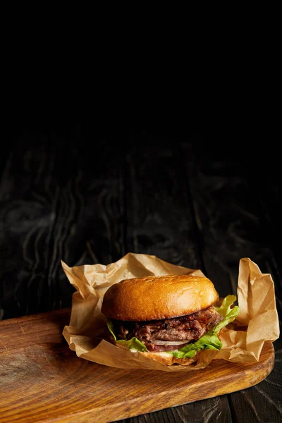 Tentant restaurant fast food avec hamburger sur planche en bois — Photo de stock