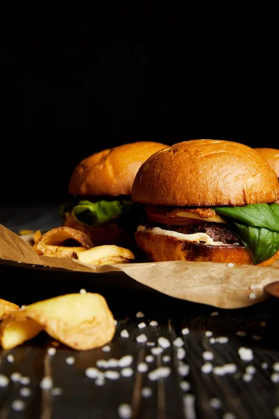 Delizioso fast food con sale sparso sulla tavola di legno — Foto stock