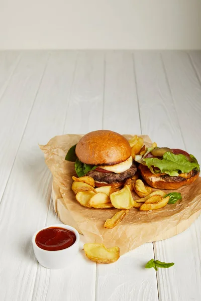 Freshly cooked hamburgers and french fries served with sauce — Stock Photo