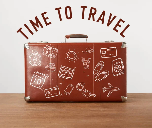 Винтажный коричневый кожаный чемодан с иконками и буквами - Время путешествовать — стоковое фото