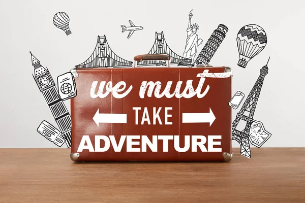 Vintage brown leather travel bag with illustration and inspiration - we must take adventure — Stock Photo