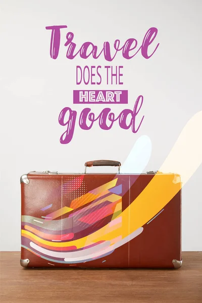 Vintage brown leather suitcase with lettering - Travel does the heart good — Stock Photo