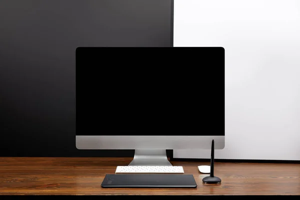 Vista de cerca del lugar de trabajo de diseño con pantalla de computadora en blanco y tableta gráfica en la mesa de madera - foto de stock