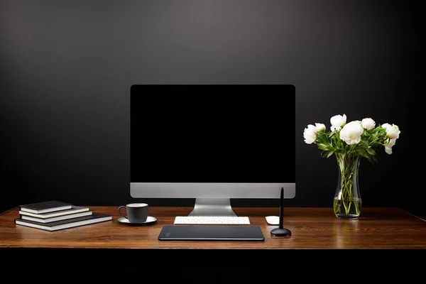 Vista ravvicinata del luogo di lavoro grafico con tablet grafico, schermo del computer vuoto, quaderni e tazza di caffè su tavolo in legno — Foto stock