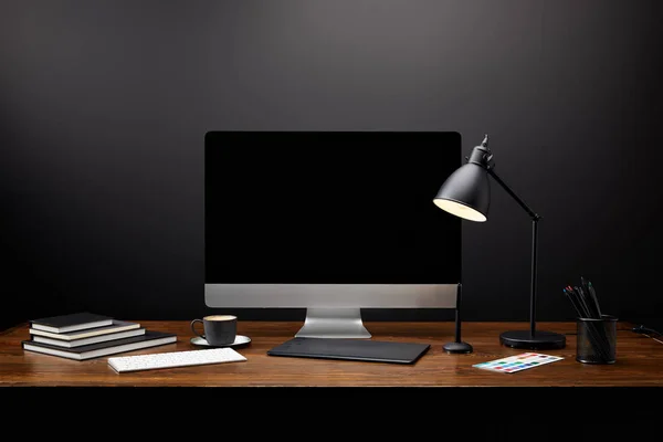 Крупный план графического дизайнера рабочего места с графическим планшетом, чистым экраном компьютера, ноутбуками и чашкой кофе на деревянном столе — стоковое фото
