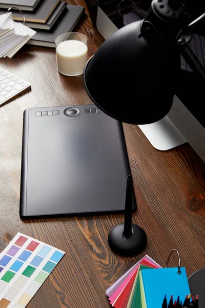 Close up view of graphic designer workplace with colorful pallet, graphic tablet and computer screen on wooden surface — Stock Photo