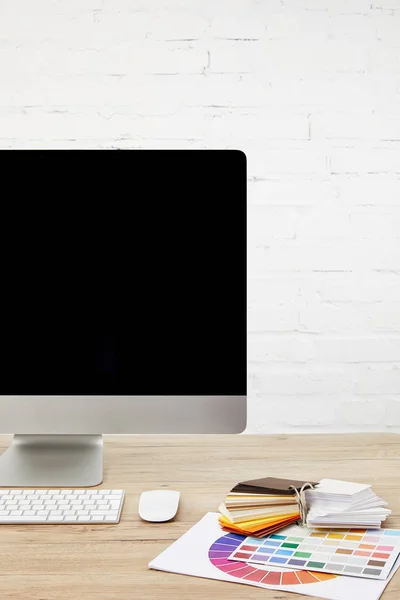 Vista de perto do espaço de trabalho do designer com palete, tela de computador em branco e teclado na superfície de madeira — Fotografia de Stock
