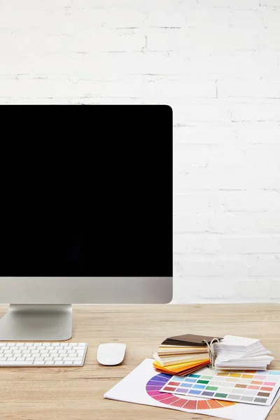 Vue rapprochée de l'espace de travail du concepteur avec palette, écran d'ordinateur vierge et clavier sur la surface en bois — Photo de stock