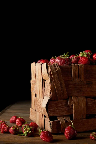 Frisch geerntete Erdbeeren in rustikaler Schachtel auf schwarz — Stockfoto