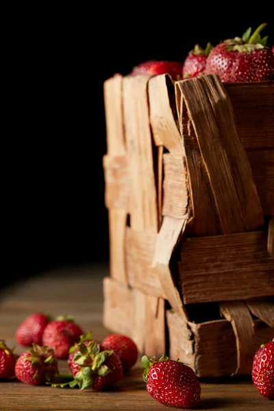 Gros plan sur les fraises mûres à la surface du bois et sur le noir — Photo de stock