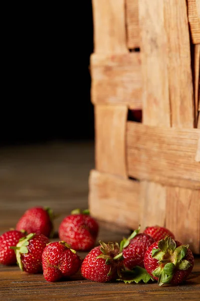Close-up shot of strawberries on wooden surface with rustic box — Stock Photo