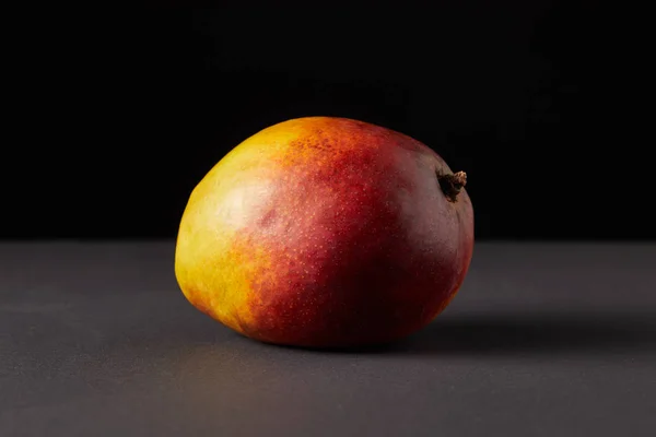 Fresh raw of mango on black background — Stock Photo