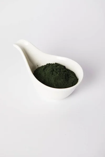 Spirulina algae powder in bowl on grey background — Stock Photo