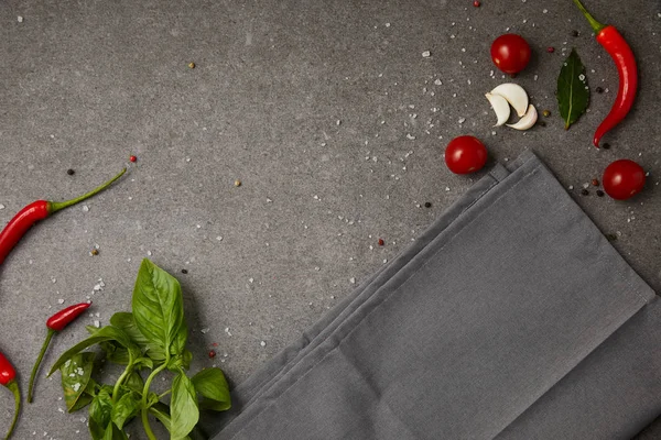 Top view of grey napkin with vegetables on grey table — Stock Photo