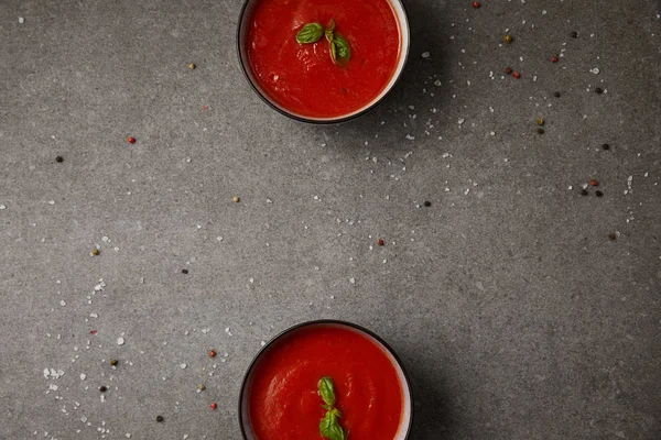 Повышенный вид на две тарелки с вкусным томатным супом на сером столе — стоковое фото