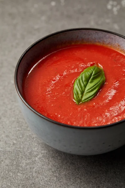 Großaufnahme des Tellers mit leckerer Tomatensuppe auf grauem Tisch — Stockfoto