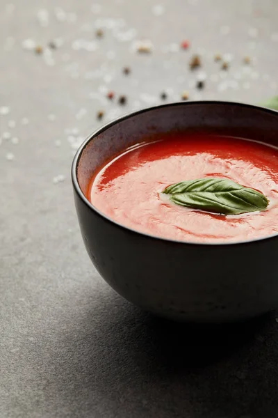 Plate with tasty tomato soup on grey table — Stock Photo