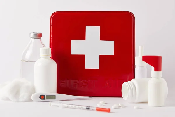 Nahaufnahme einer roten Verbandskasten-Box mit verschiedenen medizinischen Flaschen und Hilfsgütern auf weißem Grund — Stockfoto