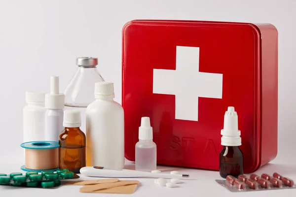 Close-up shot of first aid kit box with different medical bottles and supplies on white — Stock Photo