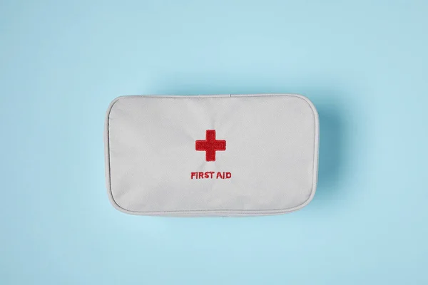 Top view of white first aid kit bag on blue surface — Stock Photo