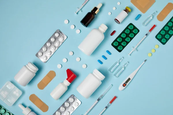 Vue de dessus de diverses fournitures médicales composées en rangée sur la surface bleue — Photo de stock