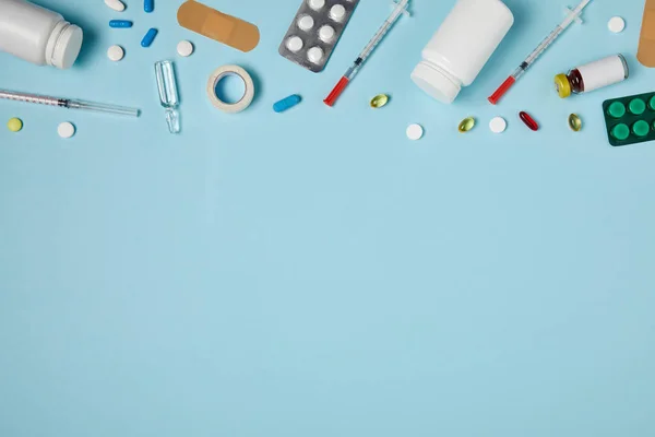 Вид сверху на различные лекарства на голубой поверхности — стоковое фото