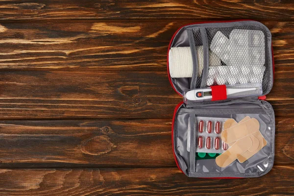Top view of opened first aid kit bag on wooden tabletop — Stock Photo