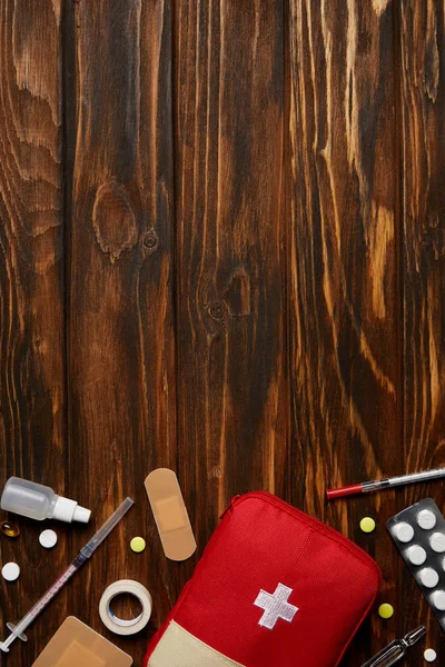 Top view of first aid kit with various medicines on wooden tabletop — Stock Photo