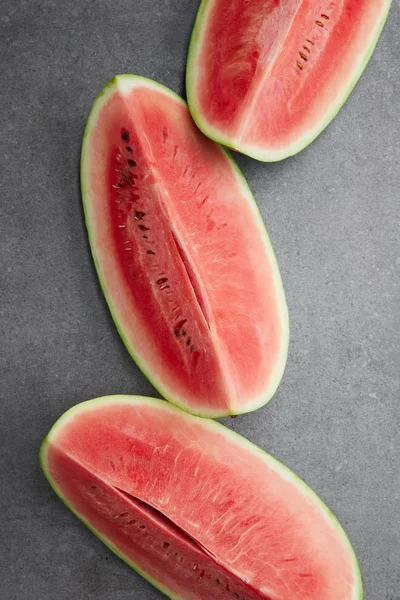 Flat lay with arranged watermelon pieces on grey concrete tabletop — Stock Photo