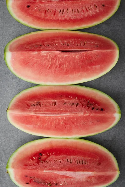 Flat lay with arranged watermelon pieces on grey concrete tabletop — Stock Photo