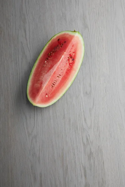 Vista superior da melancia fresca cortada metade na mesa de madeira cinza — Fotografia de Stock