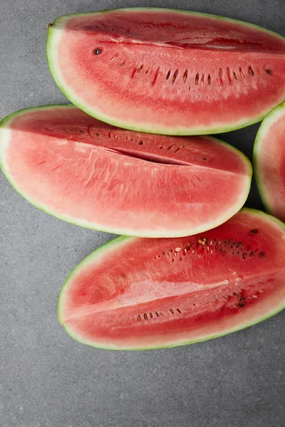 Flat lay with arranged watermelon pieces on grey concrete tabletop — Stock Photo