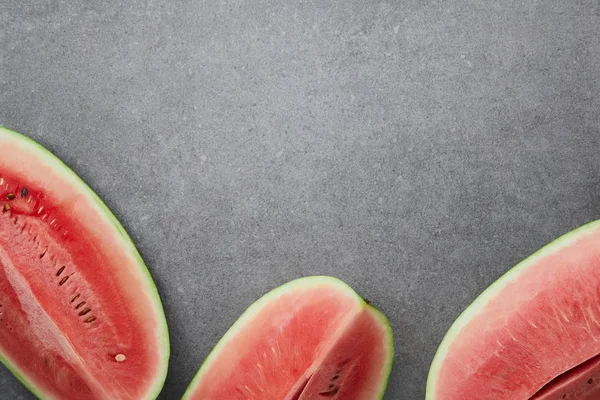 Flat lay with arranged watermelon pieces on grey concrete tabletop — Stock Photo