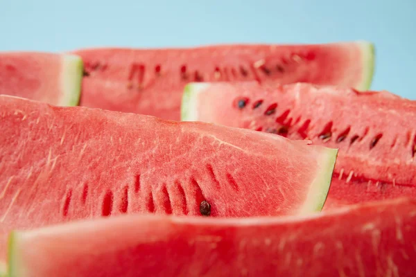 Close up view of arranged watermelon slices on white surface on blue backdrop — Stock Photo