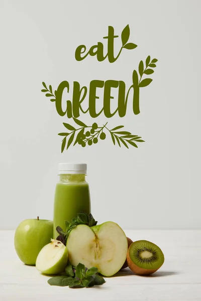 Grüner Detox-Smoothie mit Äpfeln, Kiwi und Minze und auf weißer Holzoberfläche, grüne Aufschrift essen — Stockfoto