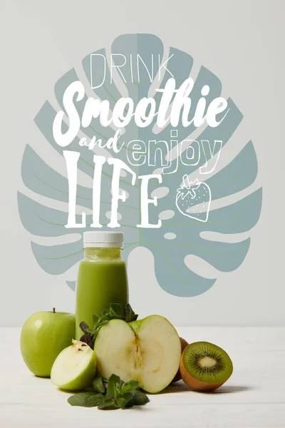 Зеленый фруктовый коктейль с яблоками, киви и мятой и на белой деревянной поверхности, пить смузи и наслаждаться жизнью надпись — стоковое фото