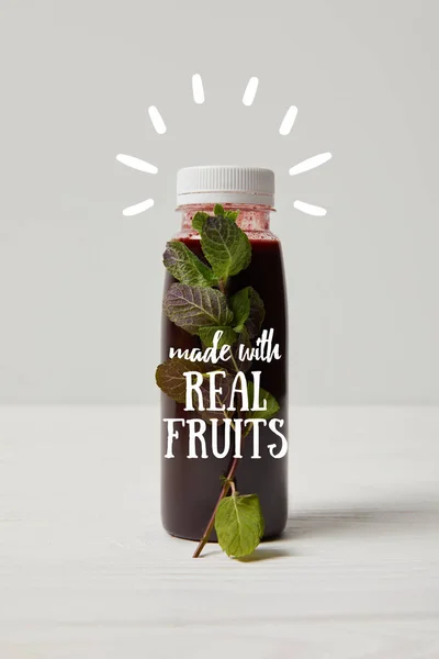 Bottle of detox smoothie with mint on white wooden surface, made with real fruits inscription — Stock Photo