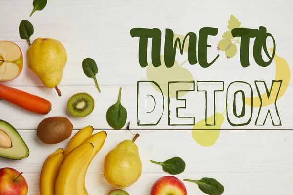 Vue de dessus des fruits frais et des feuilles d'épinards sur fond blanc en bois avec espace de copie, temps de désintoxication inscription — Photo de stock