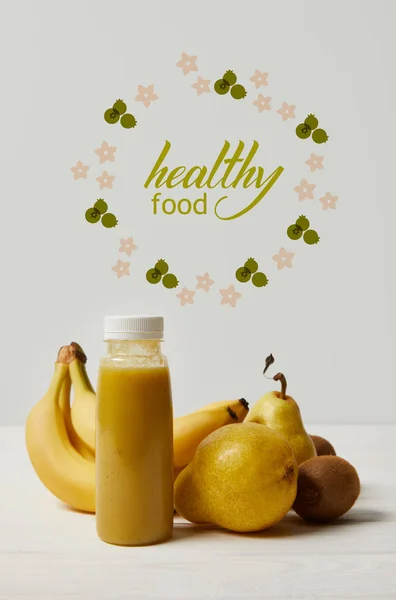 Yellow detox smoothie in bottles with bananas, pears and kiwis on white background, healthy food inscription — Stock Photo