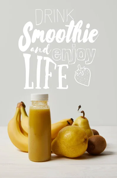 Smoothie de désintoxication jaune en bouteilles avec bananes, poires et kiwis sur fond blanc, boisson smoothie et profiter de la vie inscription — Photo de stock