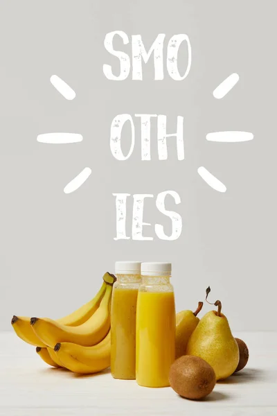 Smoothies jaunes de désintoxication en bouteilles avec bananes, poires et kiwis sur fond blanc, inscription smoothies — Photo de stock