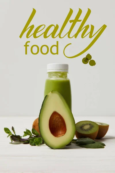 Grüner Detox-Smoothie mit Avocado, Kiwi und Minze auf weißer Holzoberfläche, Beschriftung für gesunde Lebensmittel — Stockfoto
